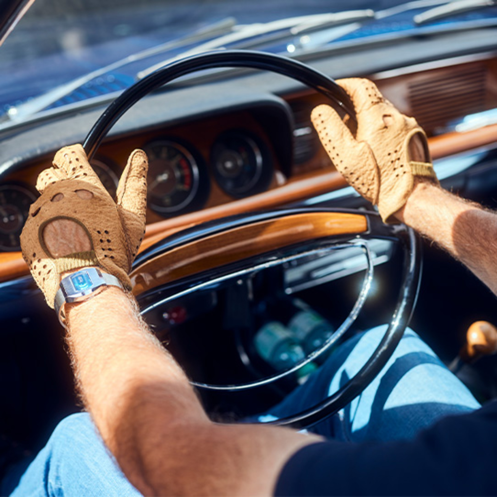 ein Mann sitzt mit Lederhandschuhen am Steuer eines BMW Oldtimers
