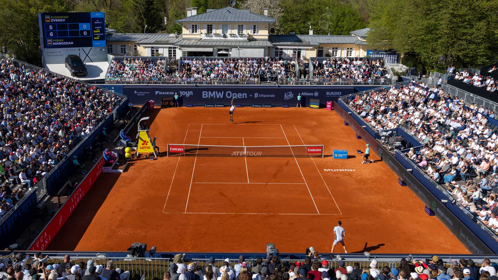 Blick von oben auf den orangefarbigen Tennisplatz