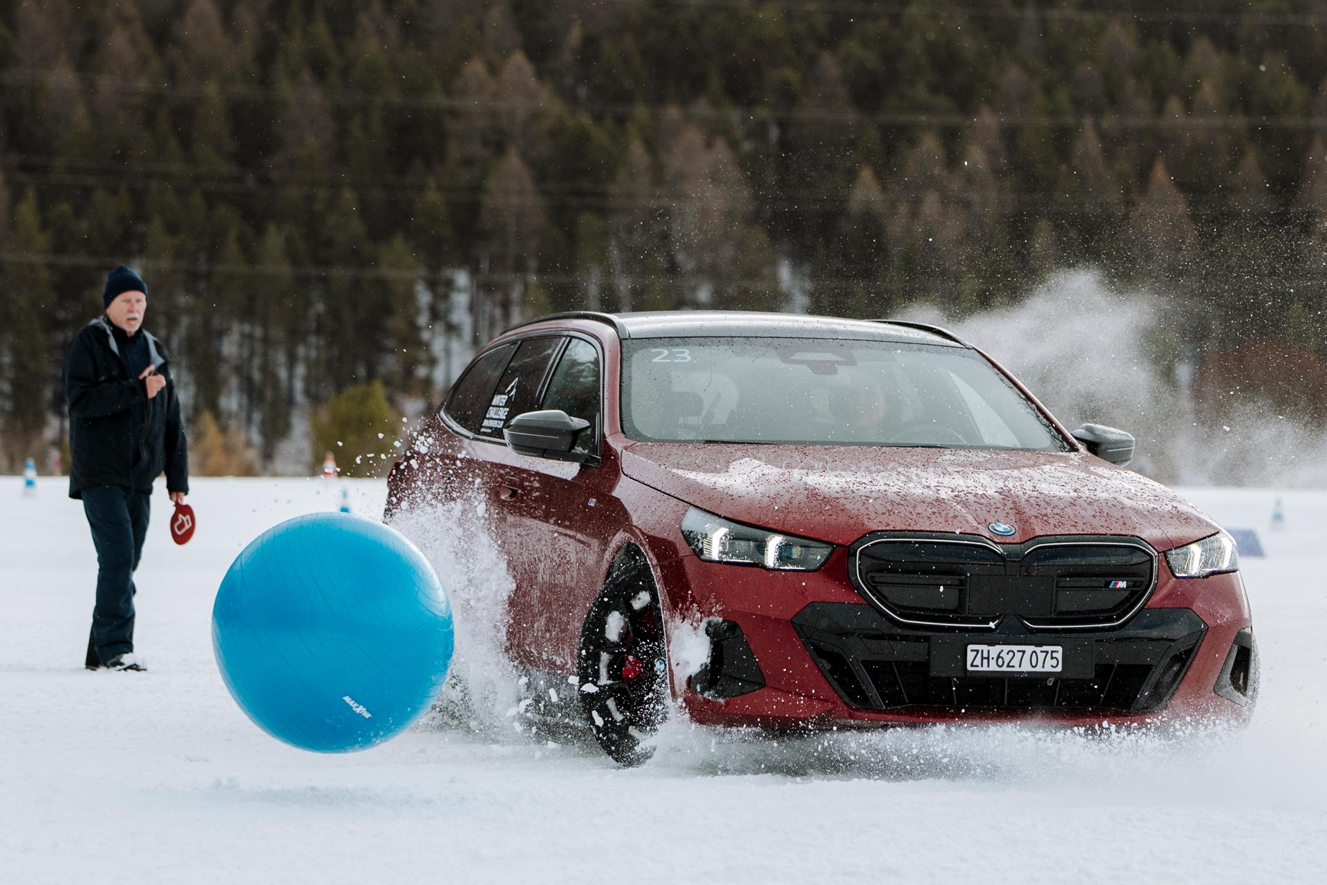 Ein roter BMW versucht im Schnee einem blauen Ball auszuweichen
